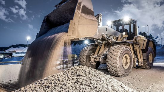 Bagger schüttet Steine aus